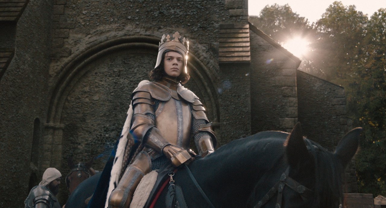 Kadras iš filmo „Sukilimas“: Woody Norman stars as "King Richard II" in director Paul Greengrass's THE UPRISING, a Focus Features release. Credit: Courtesy of Focus Features. © 2026 All Rights Reserved.
